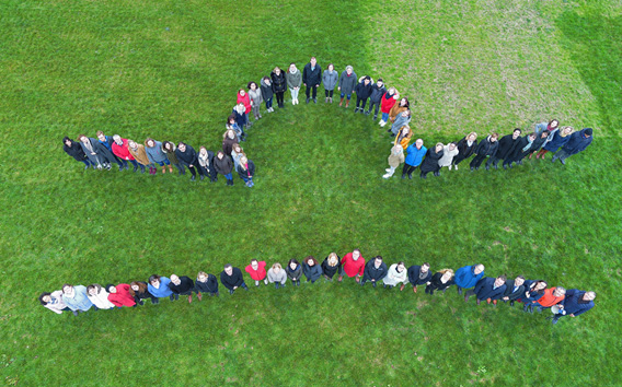 Groep mensen die het logo van Grünenthal vormen